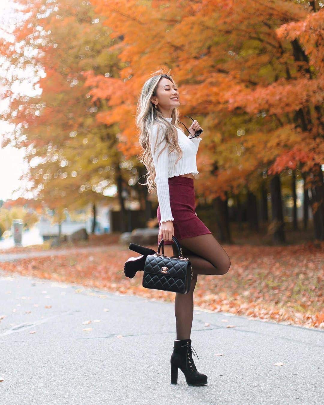 White knit sweater and burgundy skirt with boots