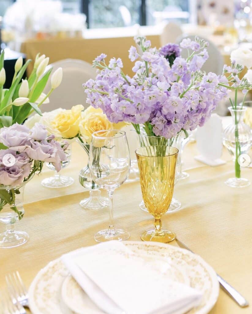 Yellow and lavender floral centerpieces with elegant table settings