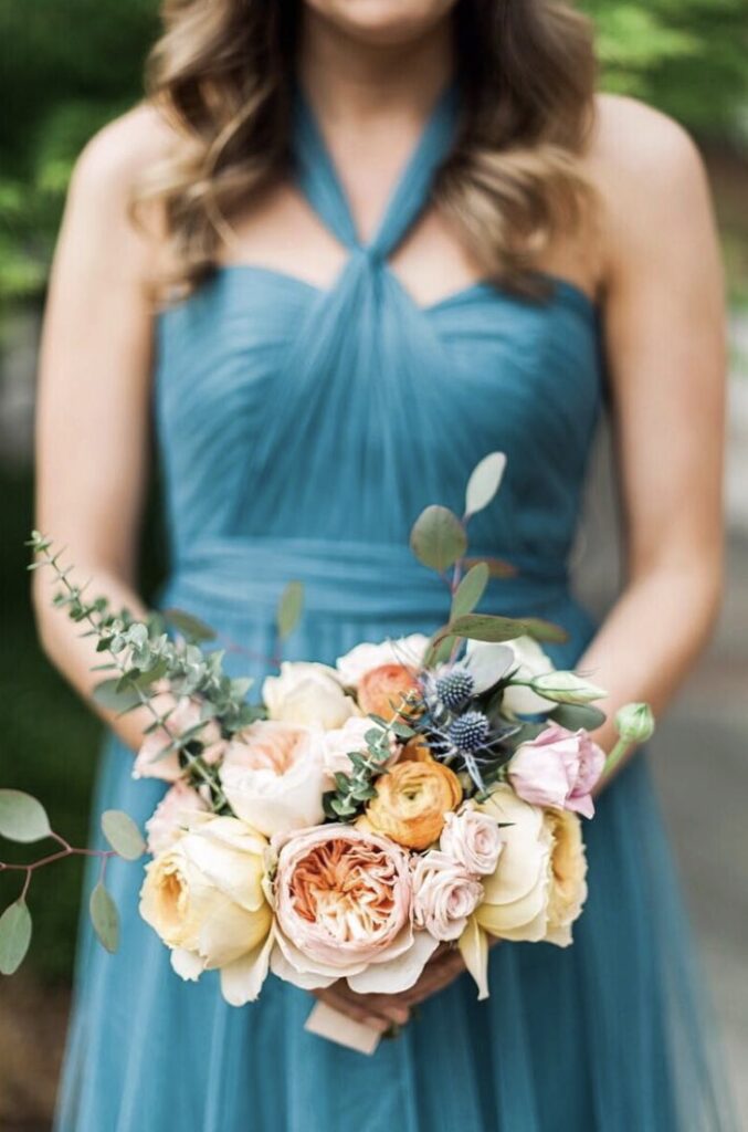 Woman in elegant blue gown holding a pastel floral bouquet