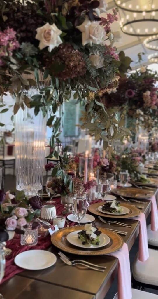 Moody floral arrangements with candlelit table decor at a wedding