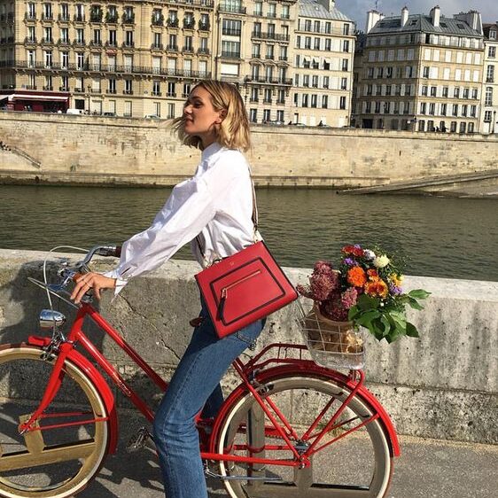 Woman on bike with red bag, Parisian fashion