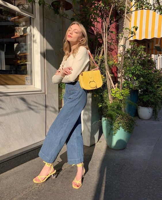 Cream sweater and jeans with yellow accents, cheerful spring style