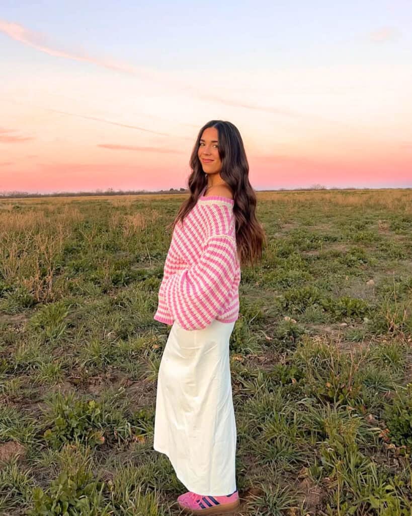 Woman in pink striped sweater and white skirt, playful spring look