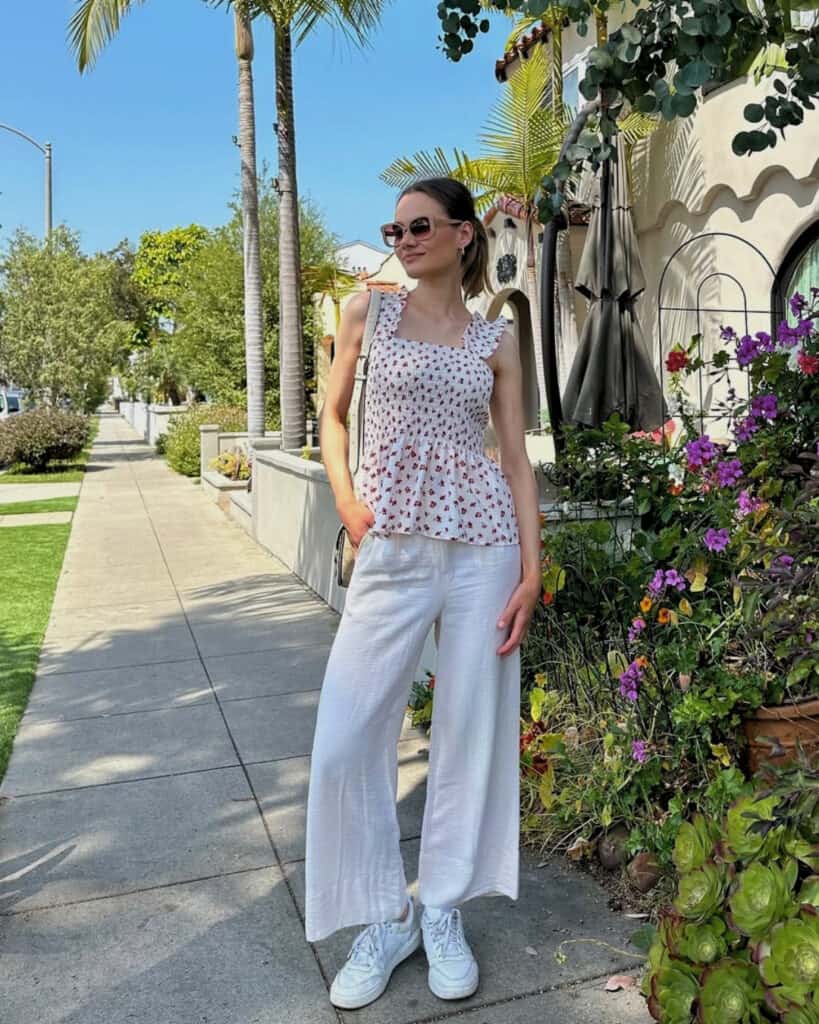 Woman in floral top and white pants, casual spring style