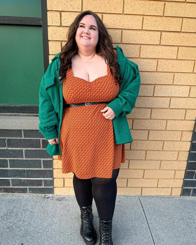 Plus size woman in earth-toned dress and green cardigan, cozy spring outfit.