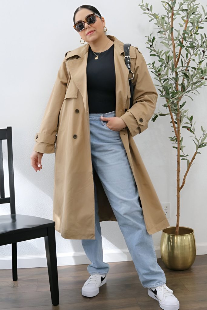 Plus size woman in trench coat and jeans, timeless spring fashion.