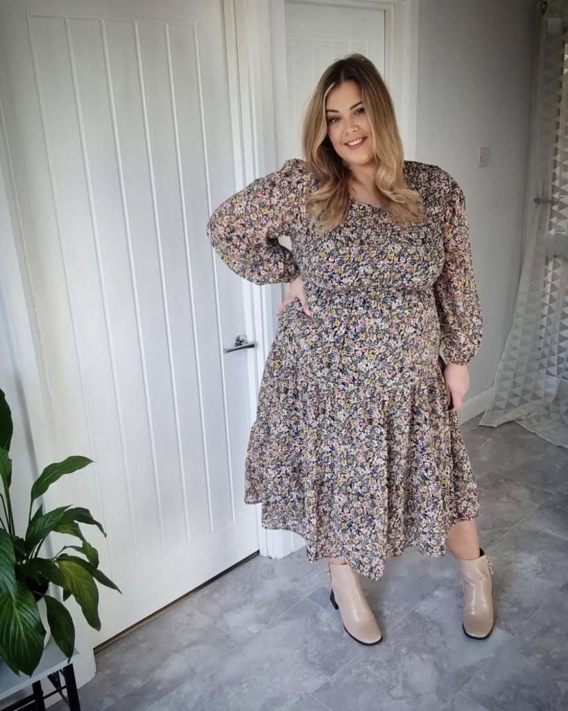 Plus size woman in floral dress, elegant spring style.