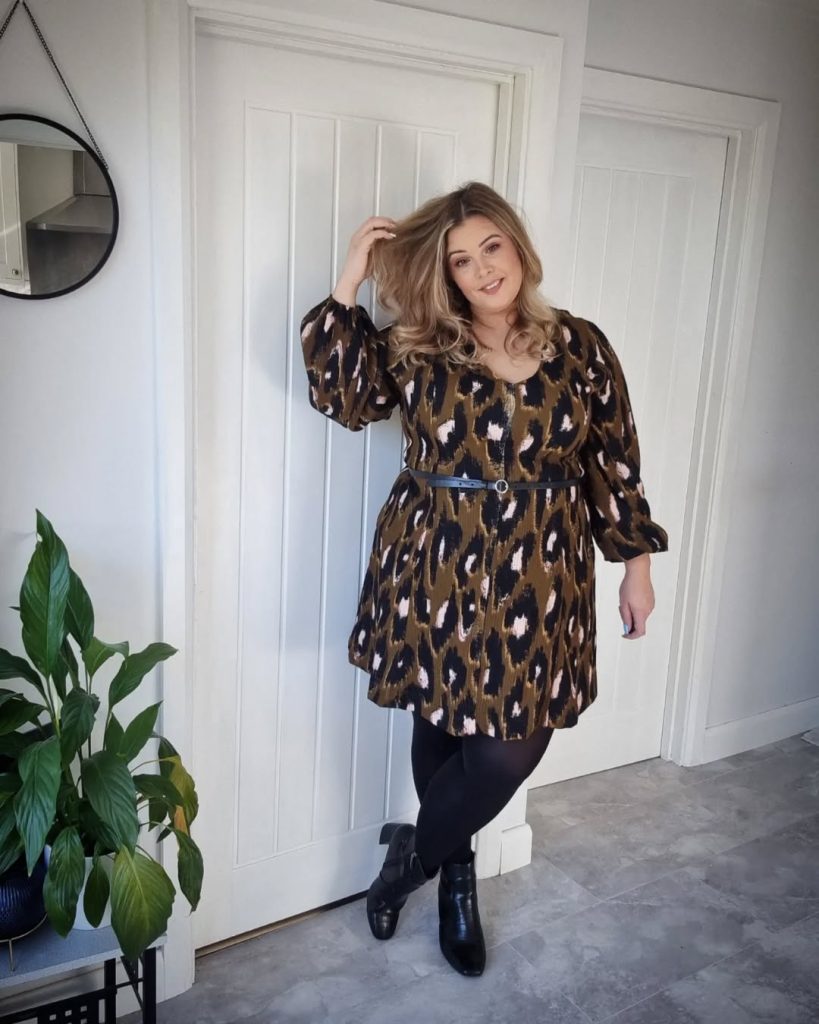 Plus size woman in animal print dress, glamorous spring style.