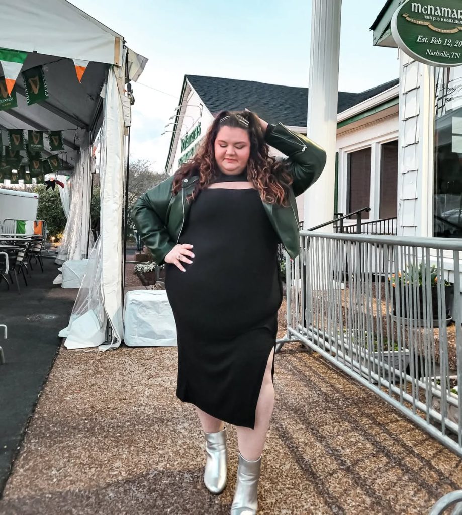 Plus size woman in black dress and metallic boots, edgy spring style.