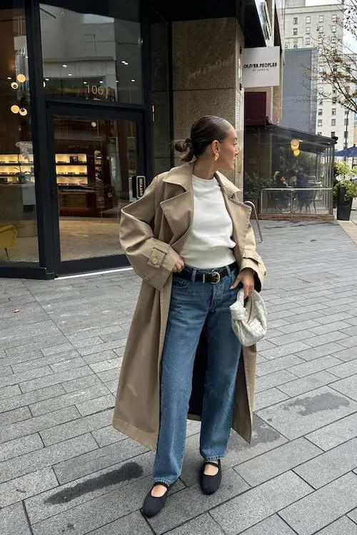 Stylish trench coat and denim outfit with modern accessories