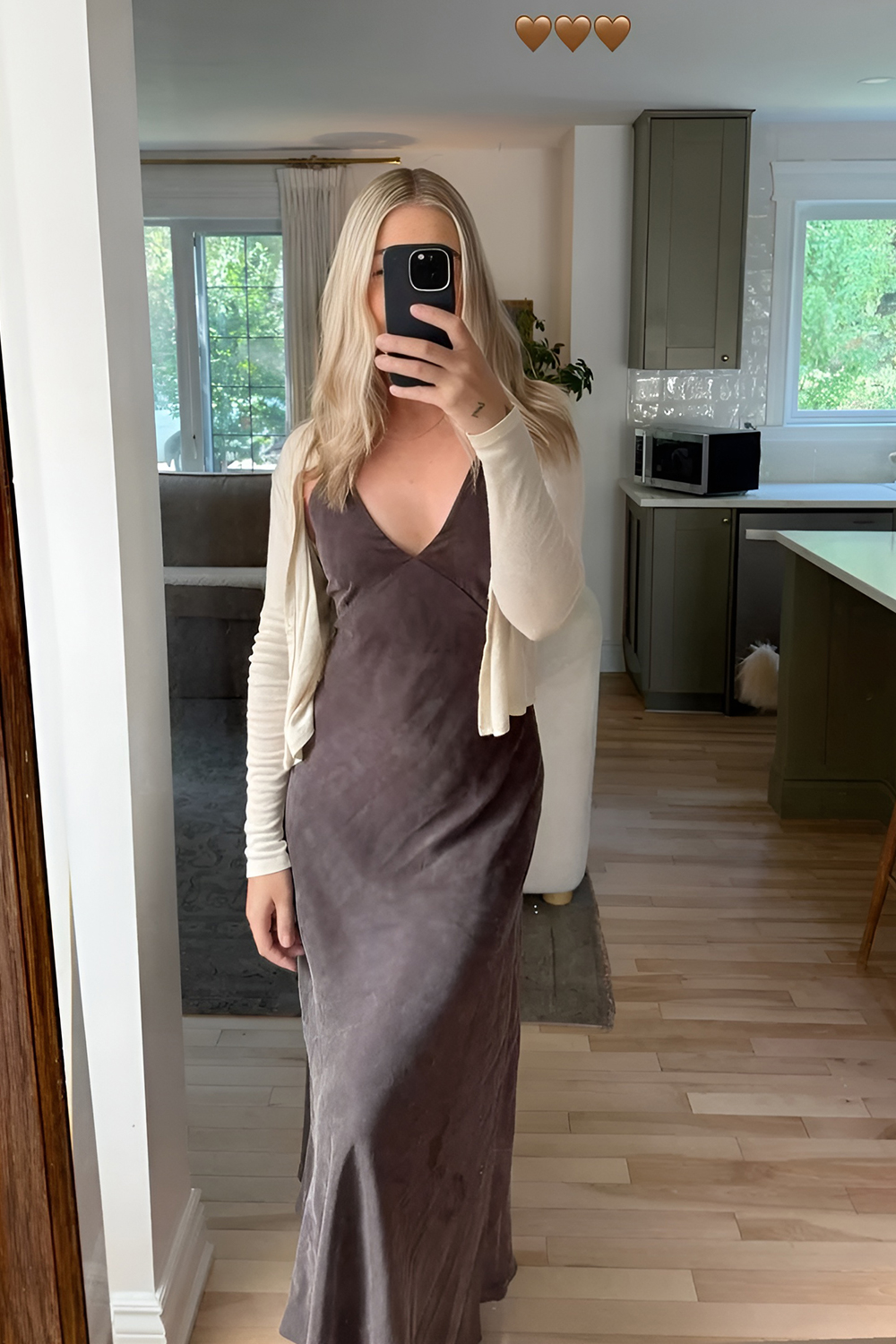 Woman in a flowy dress with a fitted cardigan and casual sandals