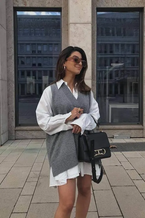 Sweater vest over a white shirt dress for a preppy look