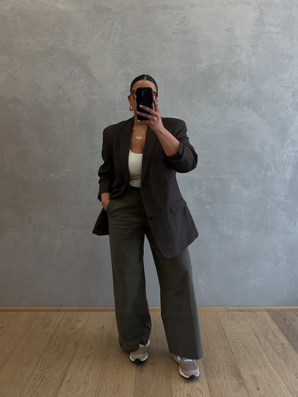 Woman in oversized blazer and wide trousers with sneakers