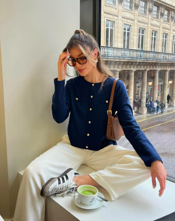 Woman in knit cardigan and white pants with sneakers