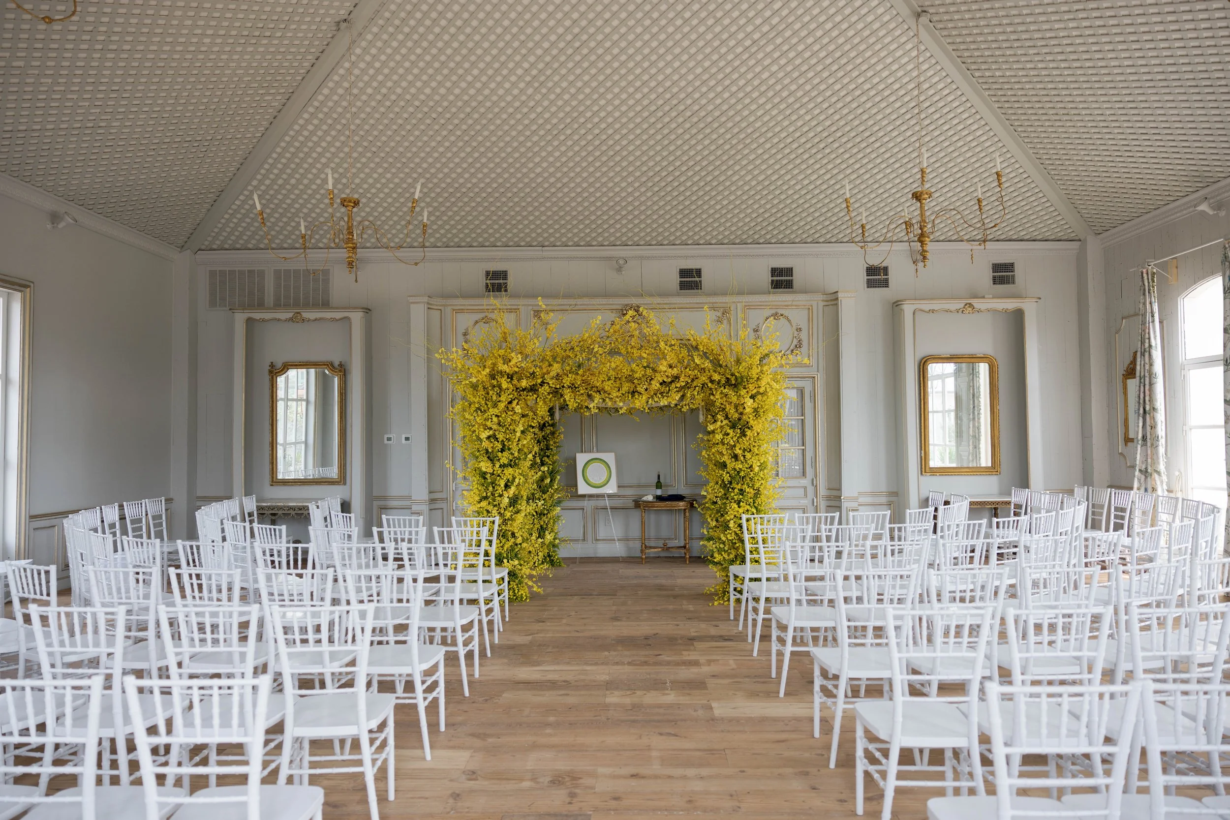 Yellow floral backdrop at indoor wedding ceremony, vibrant spring setting