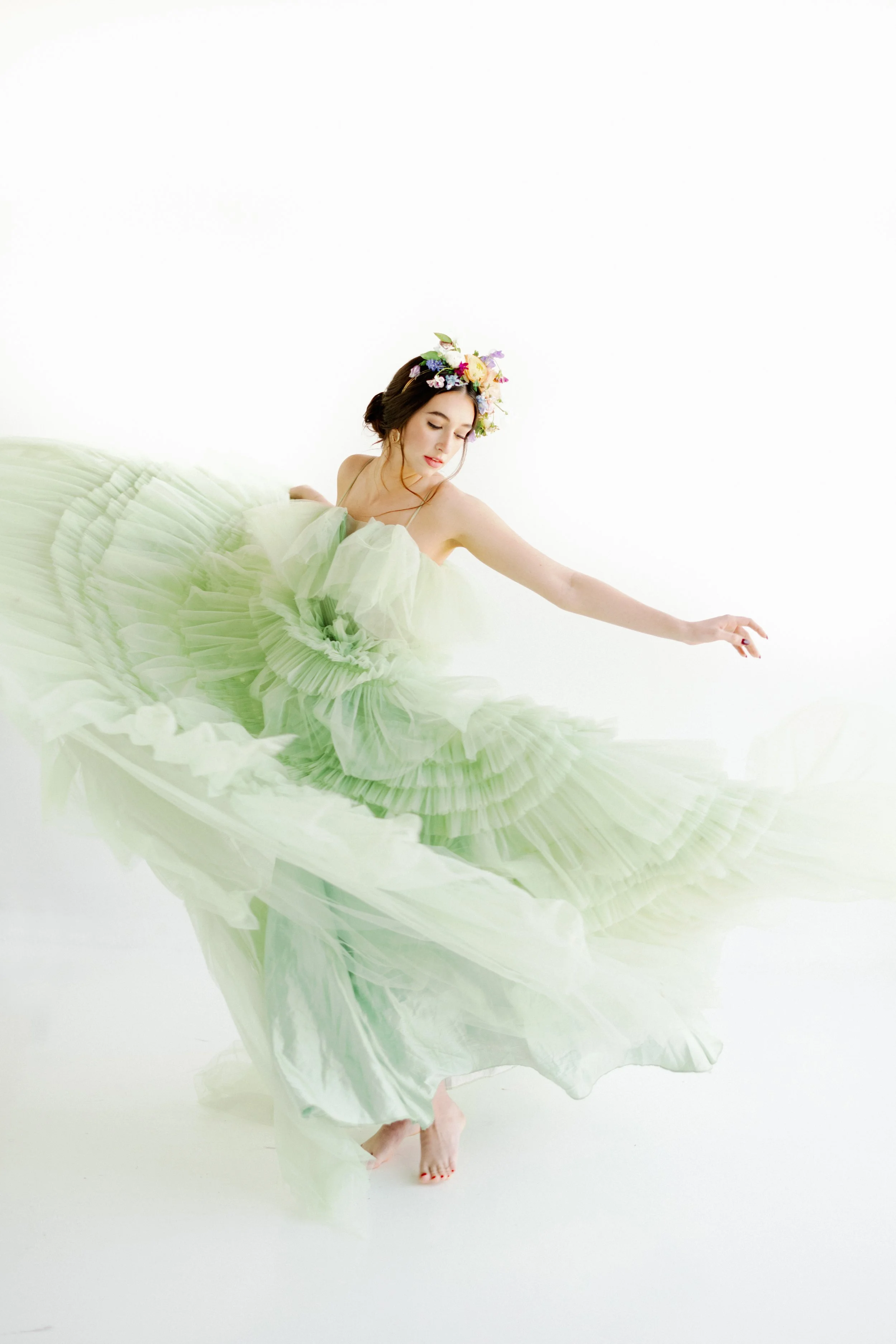 Bride in light green dress with floral crown, ethereal spring wedding look