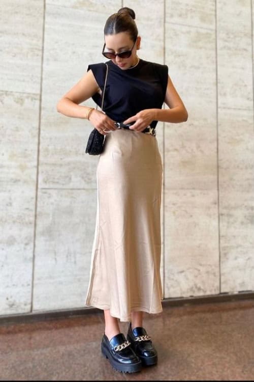 Edgy modern minimalism with black top and beige skirt for spring