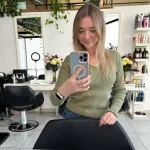 Casual spring outfit with green sweater and jeans for a relaxed office look