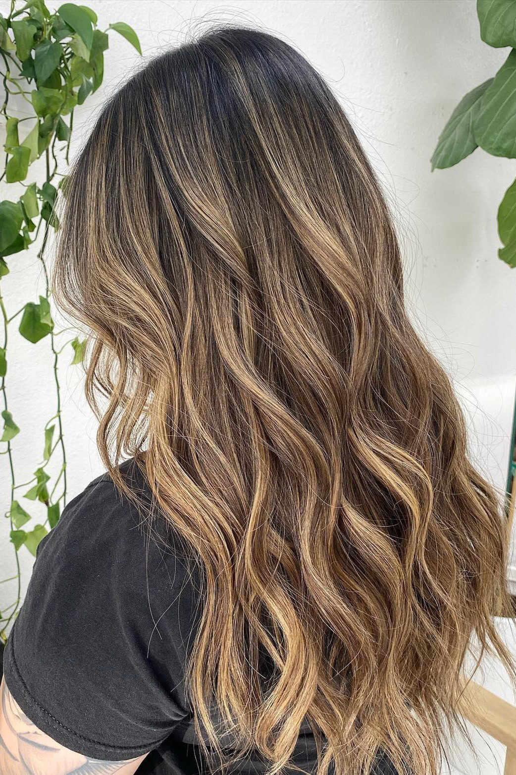 Golden balayage on wavy hair for sunlit effect