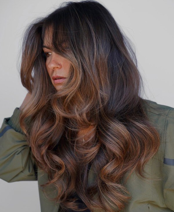 Long layered waves with caramel highlights for warmth