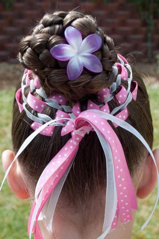 Intricate braided bun with pink ribbons and a floral accent for a festive Easter look