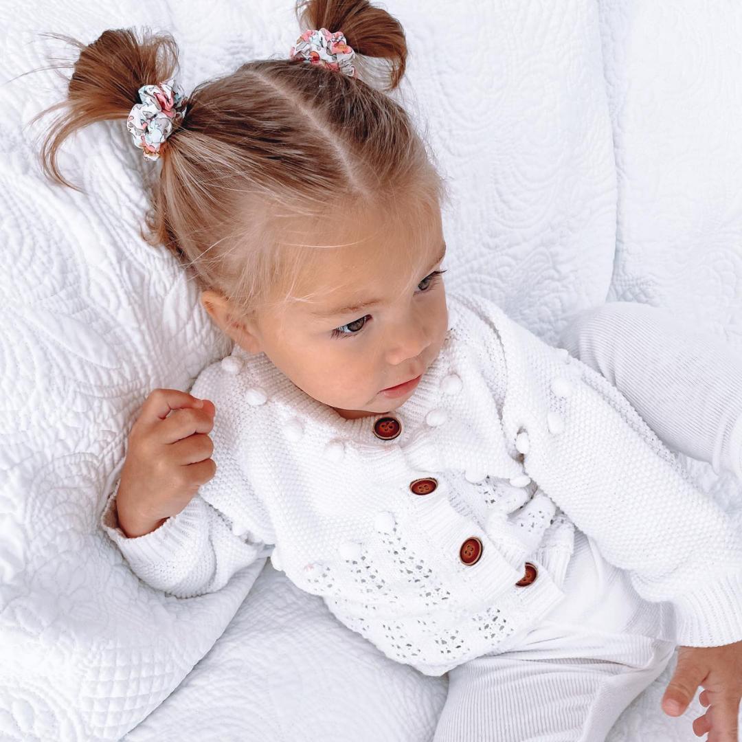 Adorable double pigtail hairstyle with floral scrunchies for a playful Easter vibe