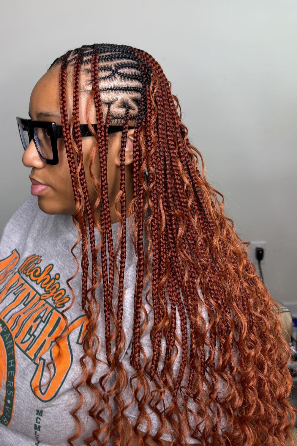 Auburn Fulani braids with loose waves and vibrant color