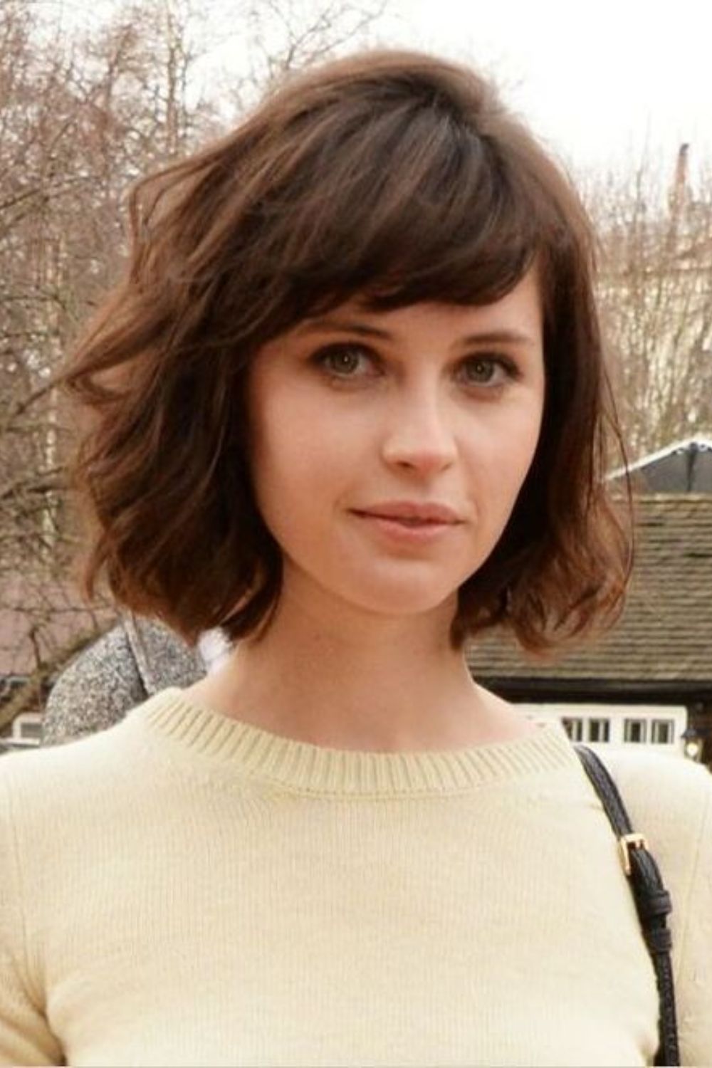Soft curly bob with side-swept bangs