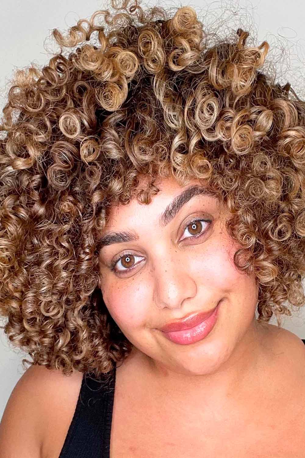 Curly bob with soft bangs and highlights