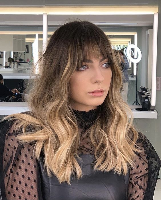 Chic wavy hairstyle with bangs, salon trend, spring 2026