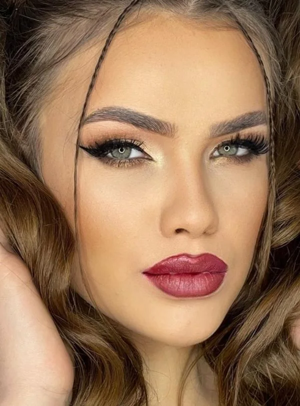 Classic makeup with subtle green eye accent and bold lips