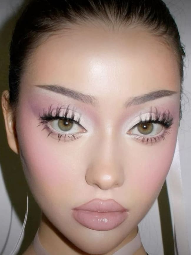 Doll-like pink makeup with exaggerated lashes