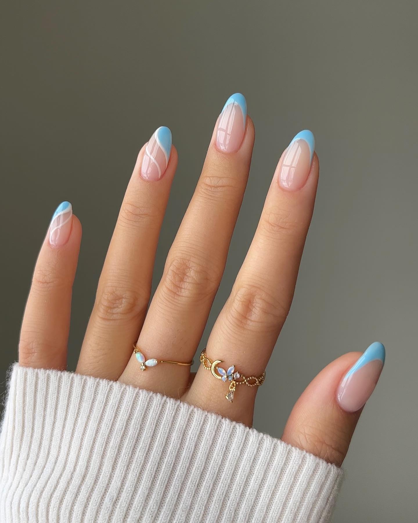 Soft blue wavy French tips on almond nails