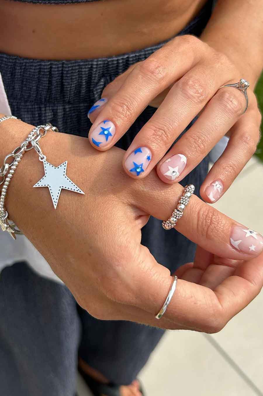 Blue and white star nail art on short, natural nails