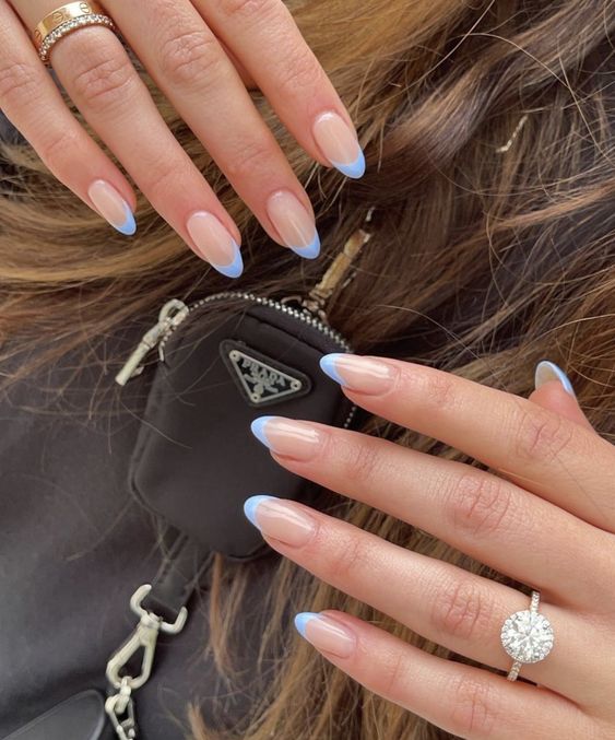 Subtle blue French tips on almond nails, minimalist elegance