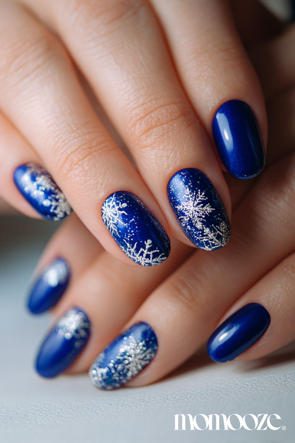 Deep blue nails with snowflake designs