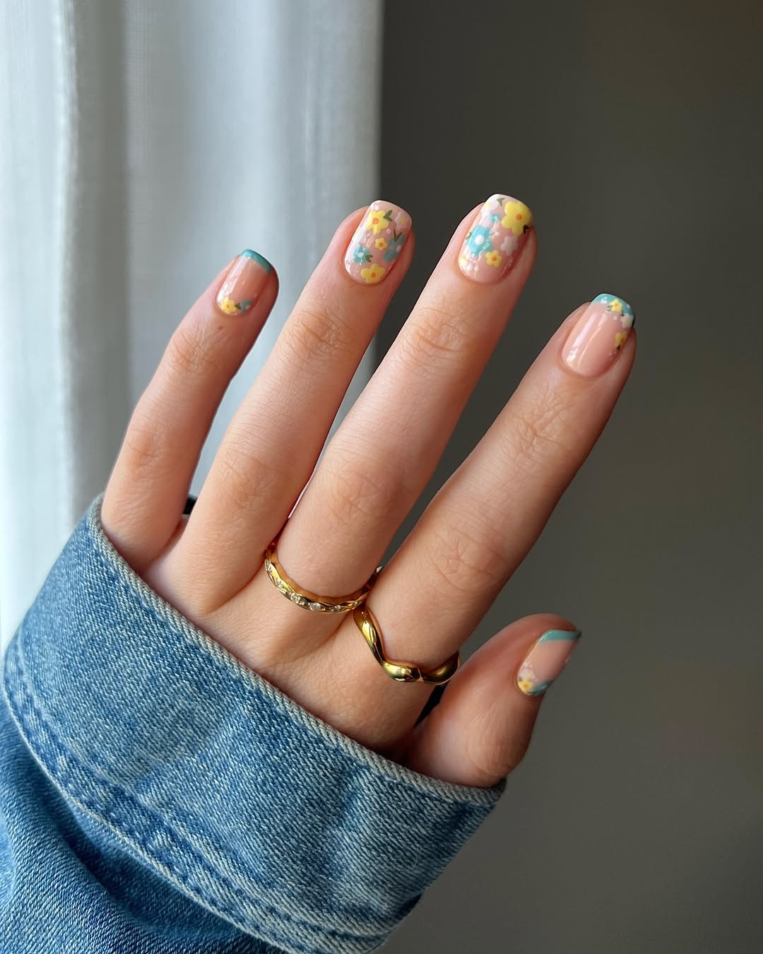 Pastel floral nail art with blue and yellow accents