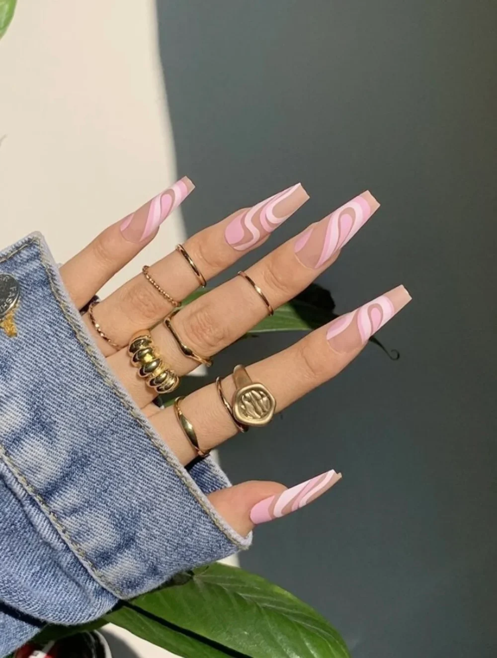 Swirling pink and blue nail art on long coffin nails