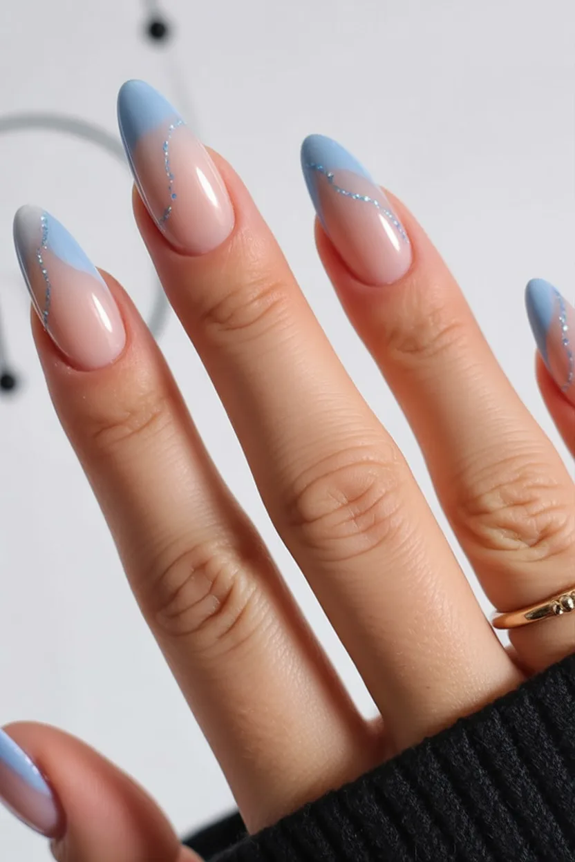 Elegant blue swirl nail art on almond nails