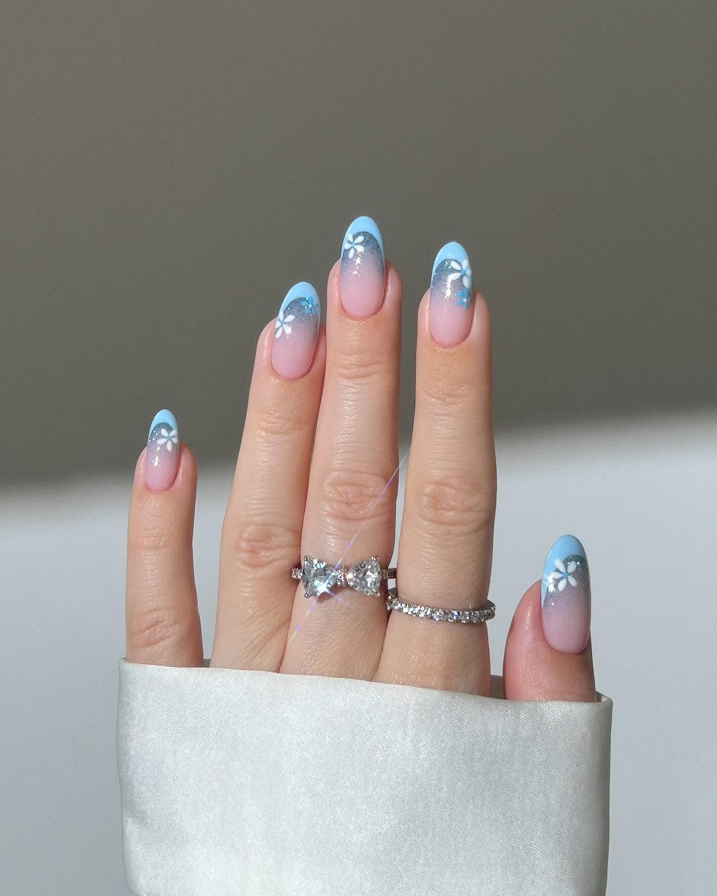 Floral ombre nails with blue tips on almond shape