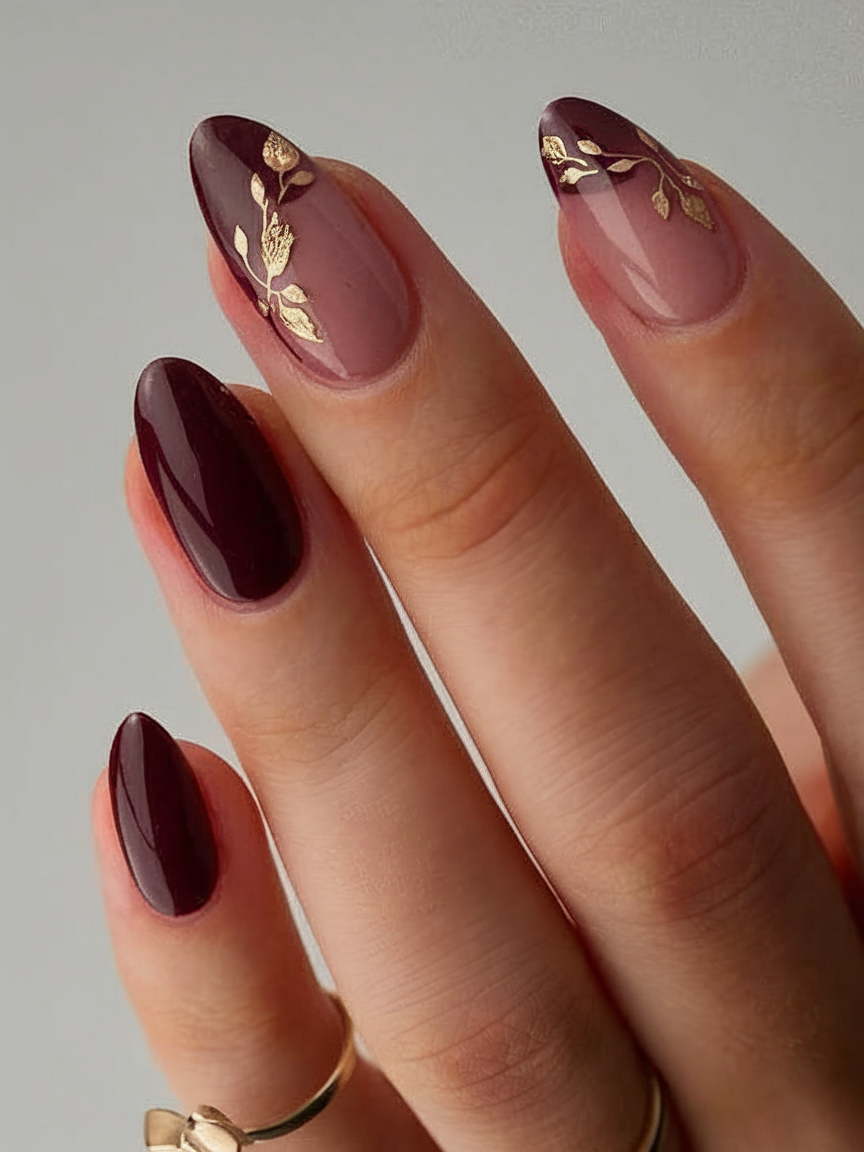 Burgundy almond nails with gold leaf accents