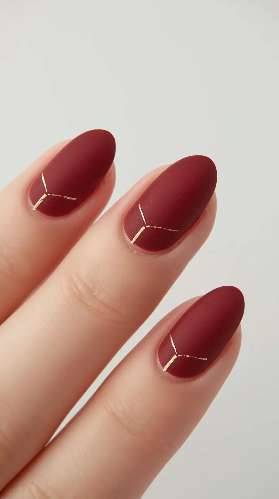Deep cherry matte nails with gold accents