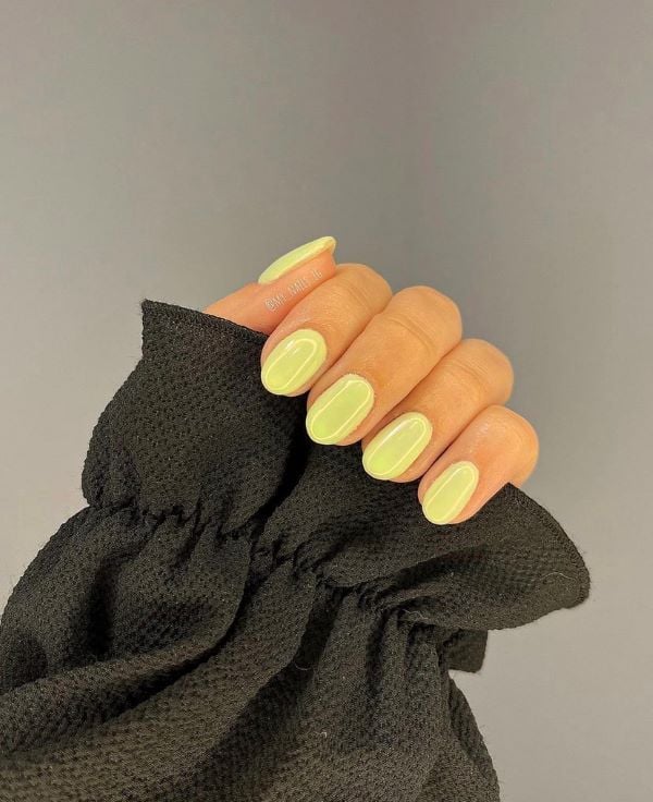 Fresh lemon yellow nails in short almond shape, perfect for summer.
