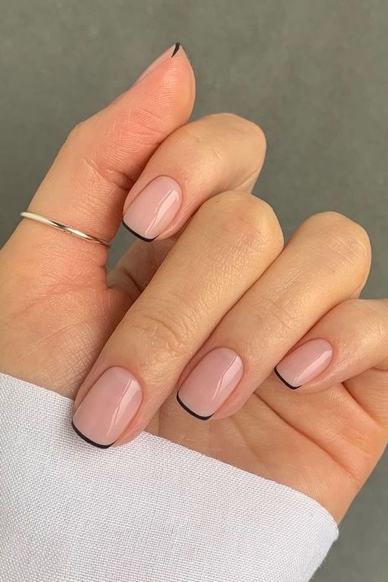 Minimalist black edge detail on nude nails.
