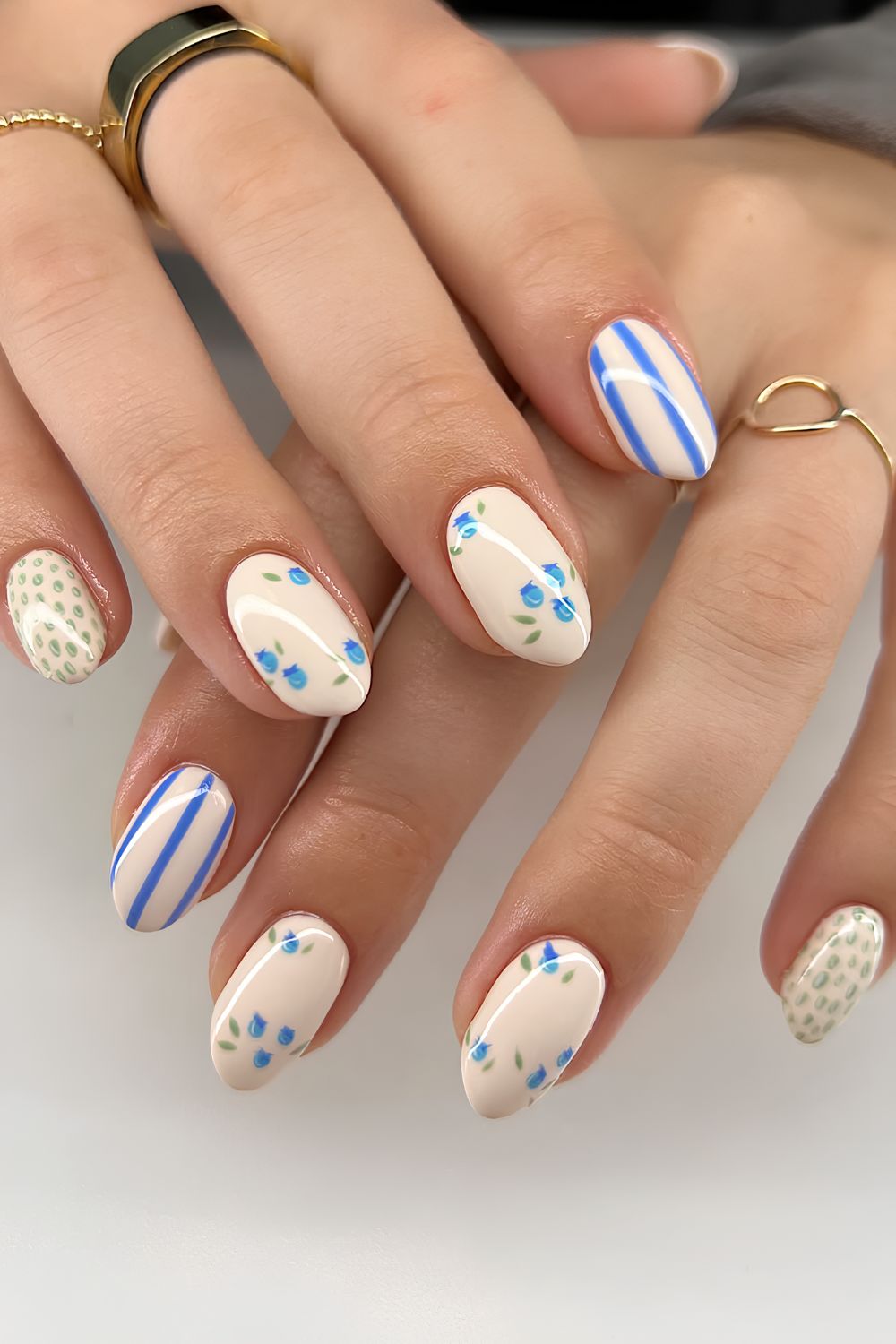 Artistic blue and white design on almond nails.