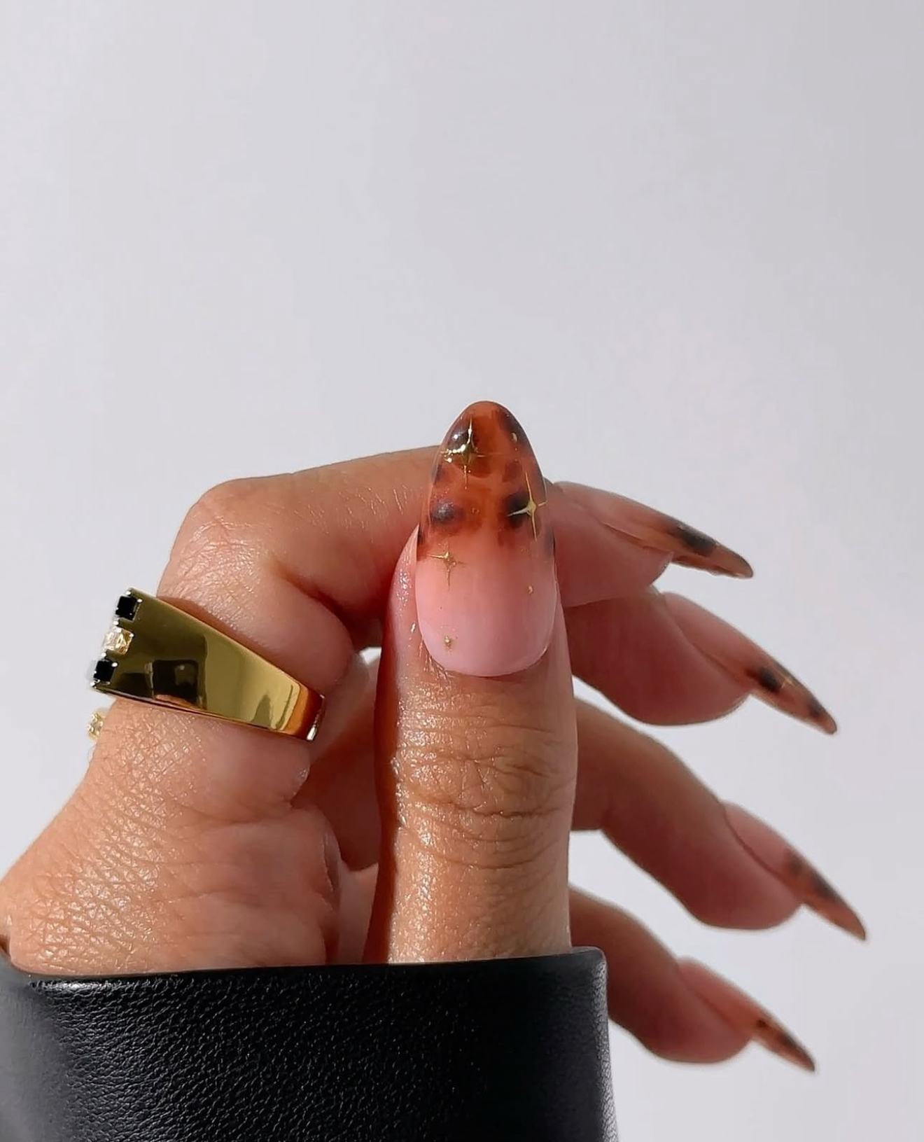 Tortoiseshell tips on nude almond nails.