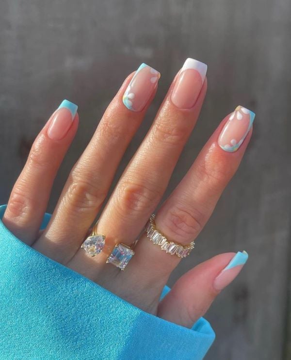 Blue French tips with floral design on square nails.