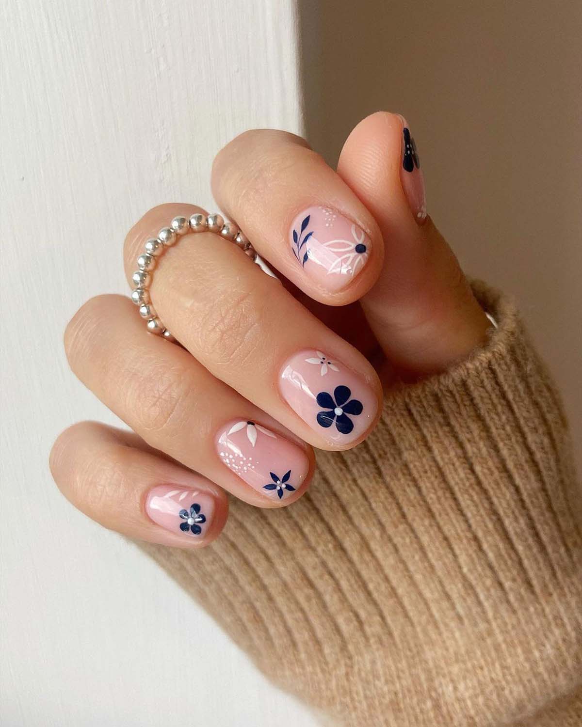 Navy and white floral on nude nails.