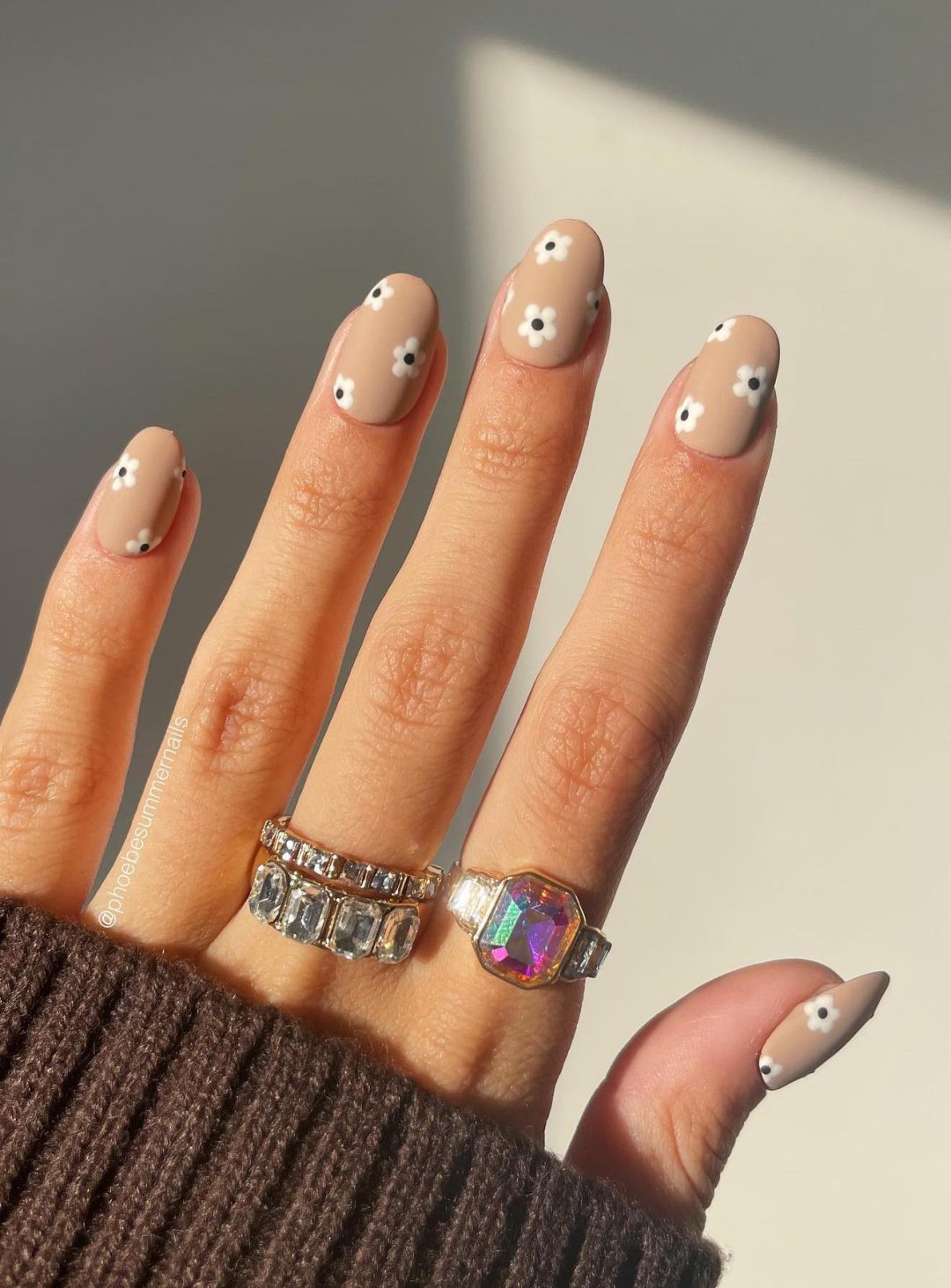 Beige nails with white daisies.