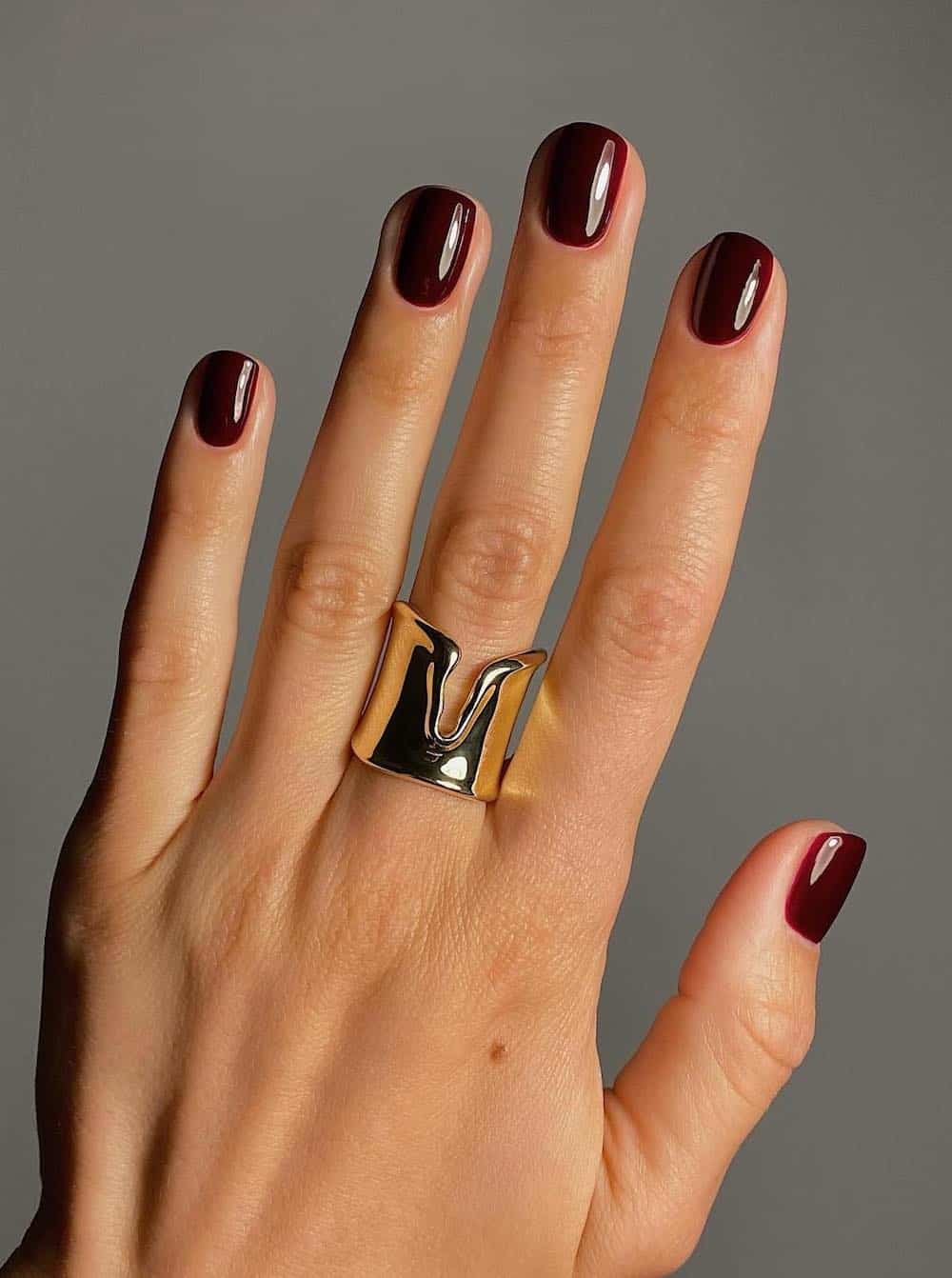 Glossy burgundy nails in a deep hue.